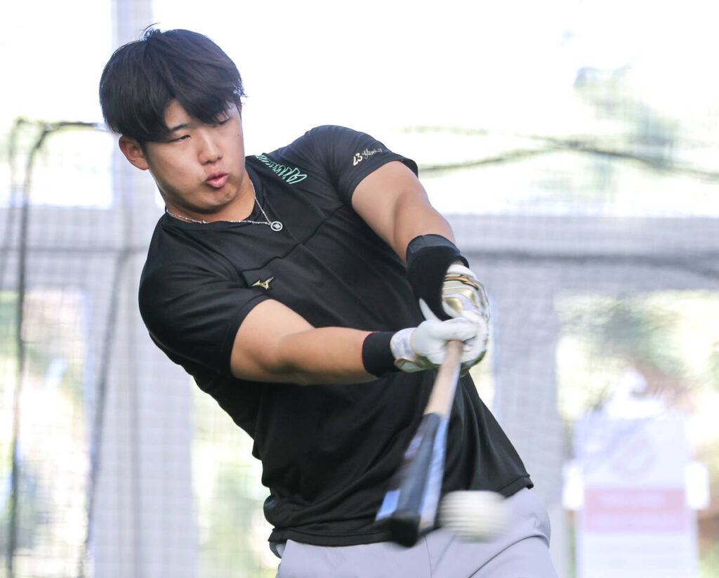 休日返上の練習でマシン打撃を行う石塚（カメラ・小林　泰斗）