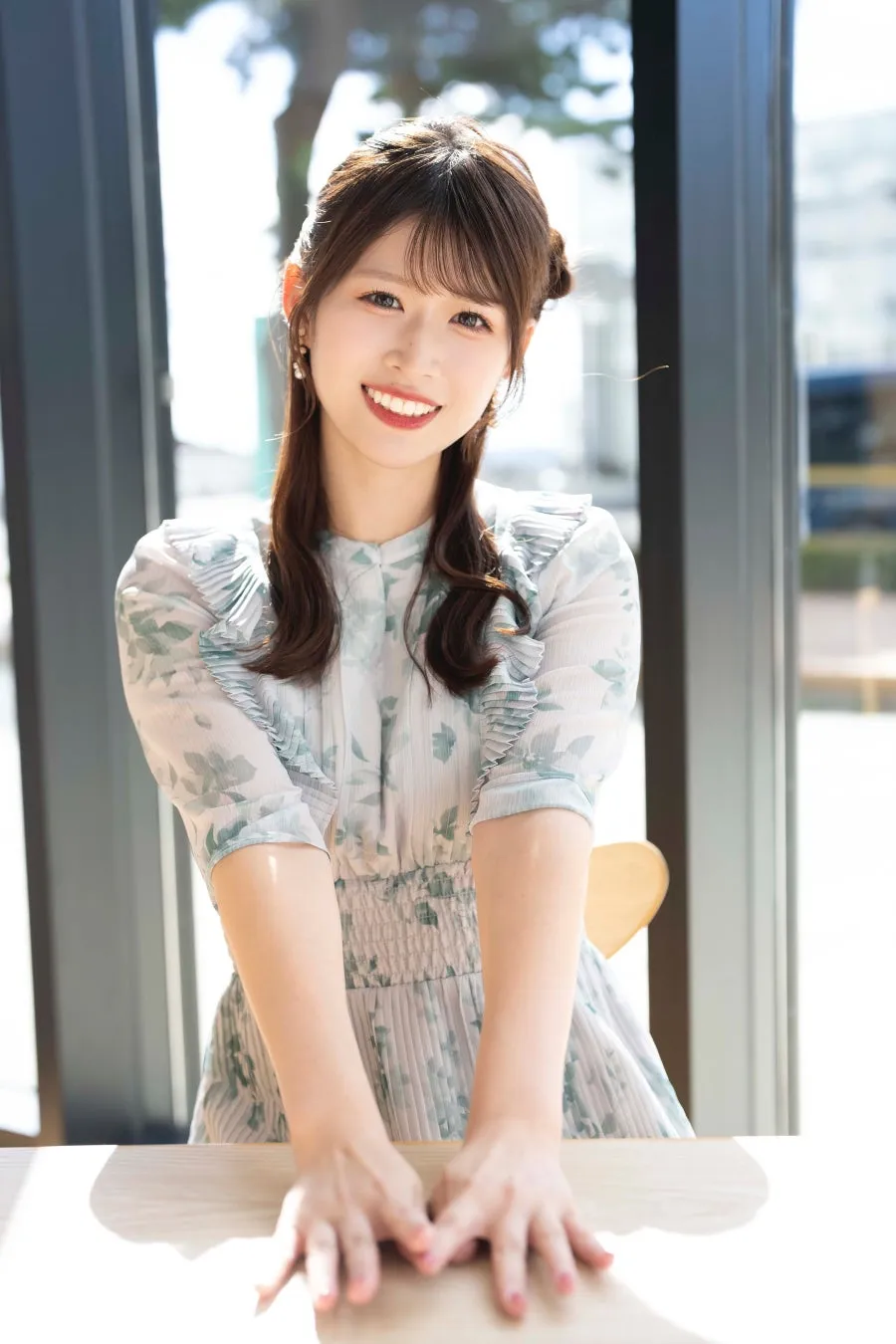 窓際で微笑む佐藤朱さん