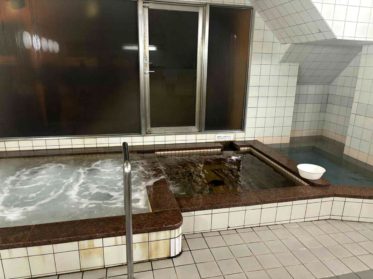 白濁して沸き立つ温泉の主浴槽とあつ湯、水風呂