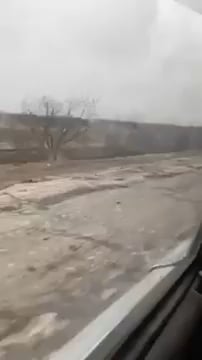 2機のSu-25M1攻撃機の標的となり破壊されたロシアの輸送船団の前を民間人が車で通り過ぎた。ヘルソン地方のクドリャヴェ村近く。