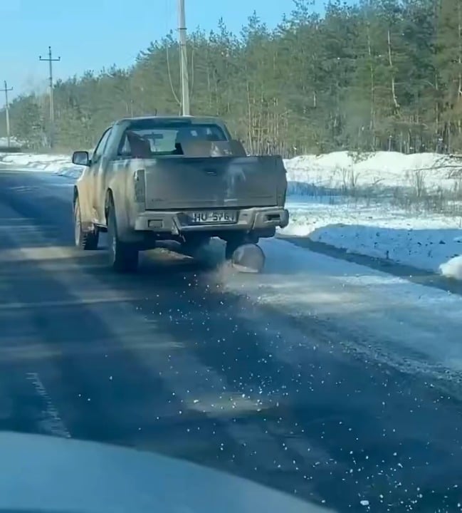 前線から帰還するウクライナのピックアップトラック、車軸の下の丸太を使って破損したタイヤを交換