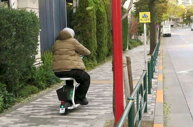 LUUPの電動シートボードで歩道を走る男性