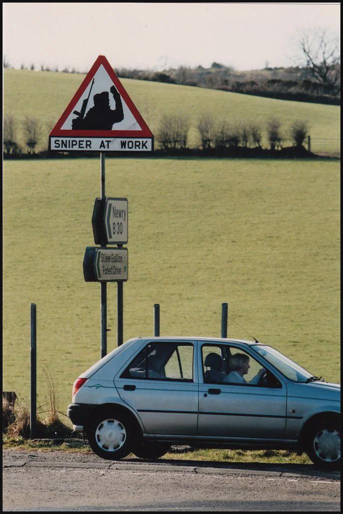 アーマー県で活動中の IRA 狙撃兵を英国軍に警告する道路標識。 (1994)