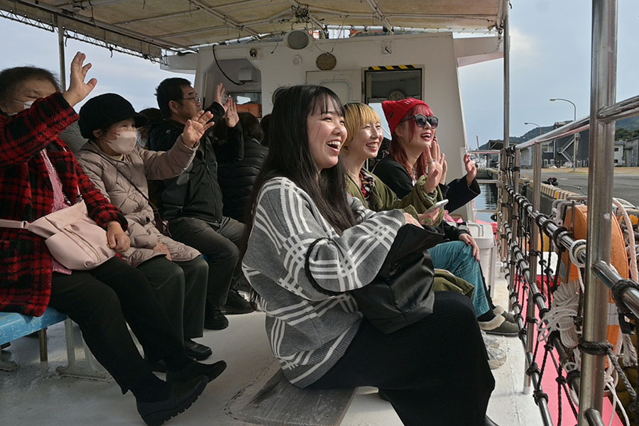 「水中観光船 マリンビューワーにちなん」のスタッフさんが手を振ってくれ、思わず笑顔になるツアーメンバー