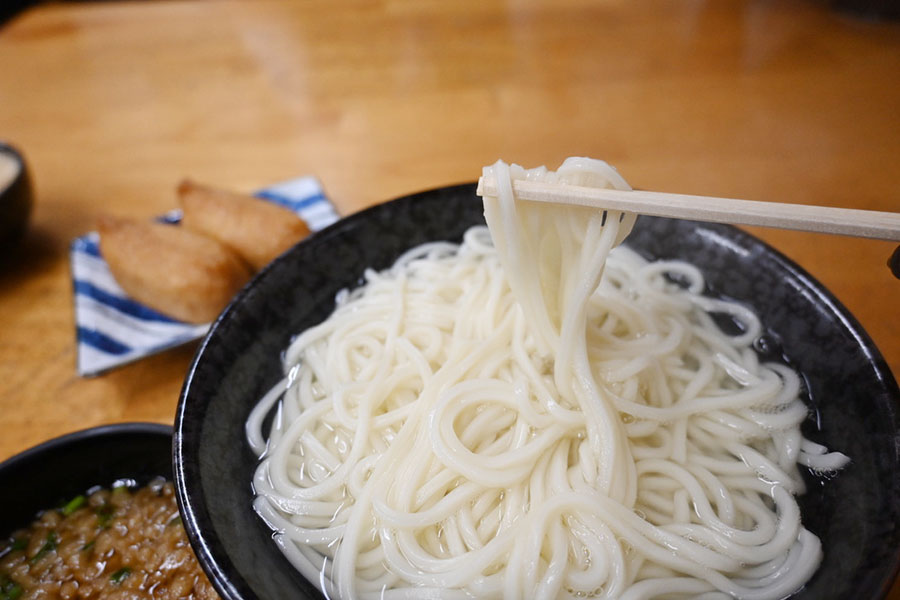 「釜揚げうどん 戸隠 本店」で釜揚げうどん（700円～）を。鰹節と昆布ダシ、そして柚子がアクセントとなったツユにつけていただく。本州ではなかなか出会わない味わいの、宮崎スタイル！