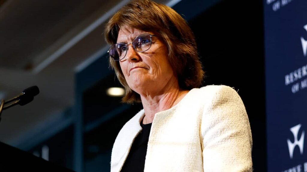 A woman speaking while standing at a lectern.
