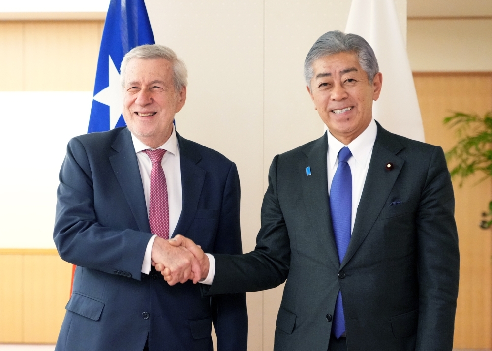 国旗の前で握手する岩屋大臣とバン・クラベレン外相