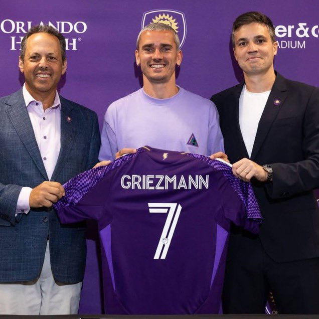 アントワーヌ·グリズマン（中央）がオーランドシティの7番ユニホームを持って微笑んでいる。 /写真=オーランドシティ公式ソーシャル·ネットワーキング·サービス（SNS）