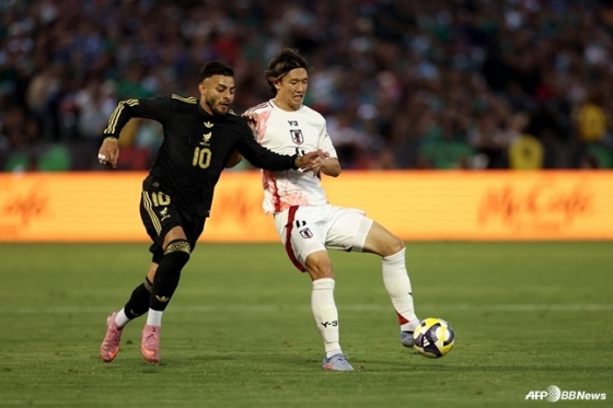 板倉高（右）が米カリフォルニア州のオークランド·アラメダ·カウンティ·コロシアムで行われたメキシコとの親善試合中、ボールを守っている。 /AFPBBNews=ニュース1