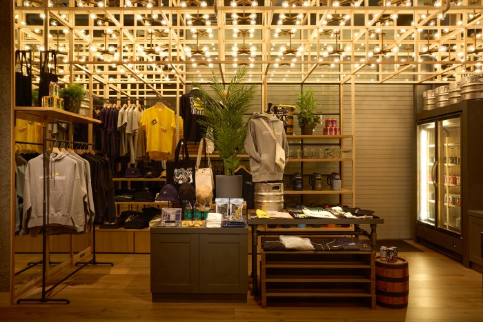 YONA YONA TOKYO BREWERYの物販スペース。中央のテーブルを囲むようにハンガーラックがある。