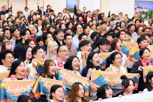 台湾と群馬の友が、はじける笑顔で記念のカメラに。台湾の友が持つタオルには、「冬必為春」（冬は必ず春となる）との文字が