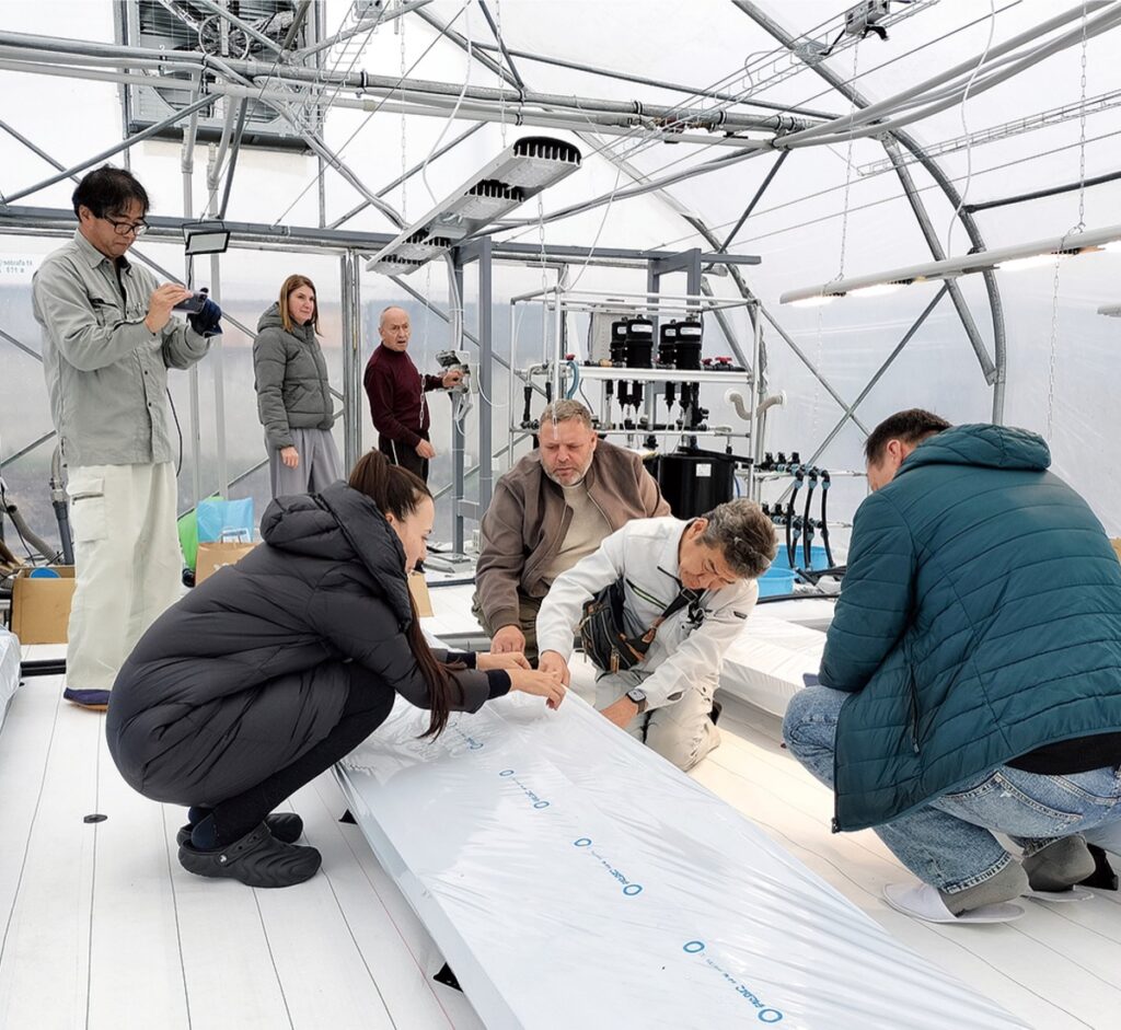 メビオール 戦禍のウクライナに実り フィルム農法で復興支援 | 平塚・大磯・二宮・中井 ウクライナで関係者とハウスで作業する吉岡さん(右から2人目 写真提供)