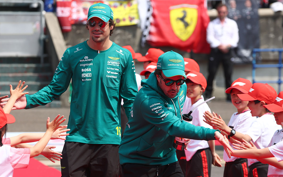 子どもたちとハイタッチを交わしながら笑顔で歩くアストンマーティン・ホンダのランス・ストロールとフェルナンド・アロンソ、2026年3月29日(日) F1日本GP決勝前セレモニー（鈴鹿サーキット）