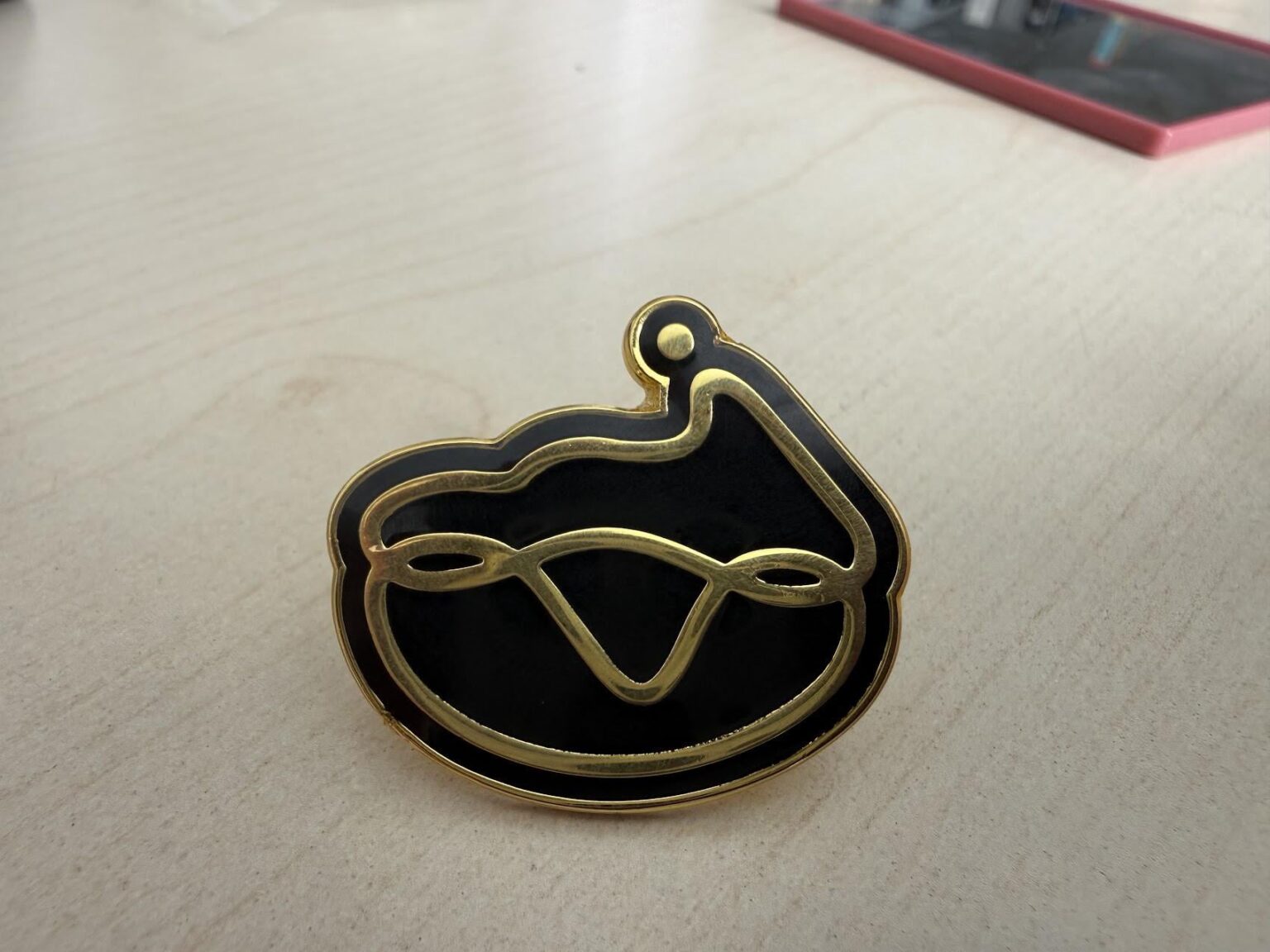 このロゴは何ですか?このピンは、ドイツのオフィスの共用エリアに何ヶ月も置かれています。 GoogleレンズとAIモデルは役に立たなかった...