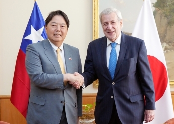 正面を向き、笑顔で握手を交わす、両大臣の様子