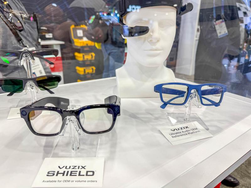 展示会の台の上にVuzixのスマートグラスが並び、マネキンがARグラスを装着している様子