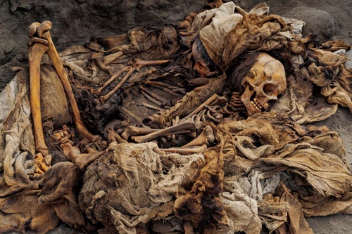ペルー北部の太平洋岸にある集団墓地で見つかった2人の子どもの遺体。15世紀半ば、チムー王国の都だったチャン・チャンの近くで、多くの子どもが生け贄として殺された。これまでに2カ所の集団墓地から269人の子どもの遺体が発見されている。彼らの多くが胸部を切り裂かれ、心臓を取り出されたようだ。（PHOTOGRAPH BY ROBERT CLARK