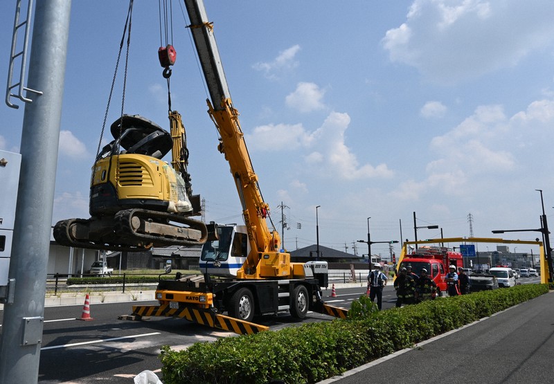 落下事故の後、レッカー車で市道から移動されるショベルカー＝和歌山市栗栖で2025年8月26日午前11時3分、藤木俊治撮影
