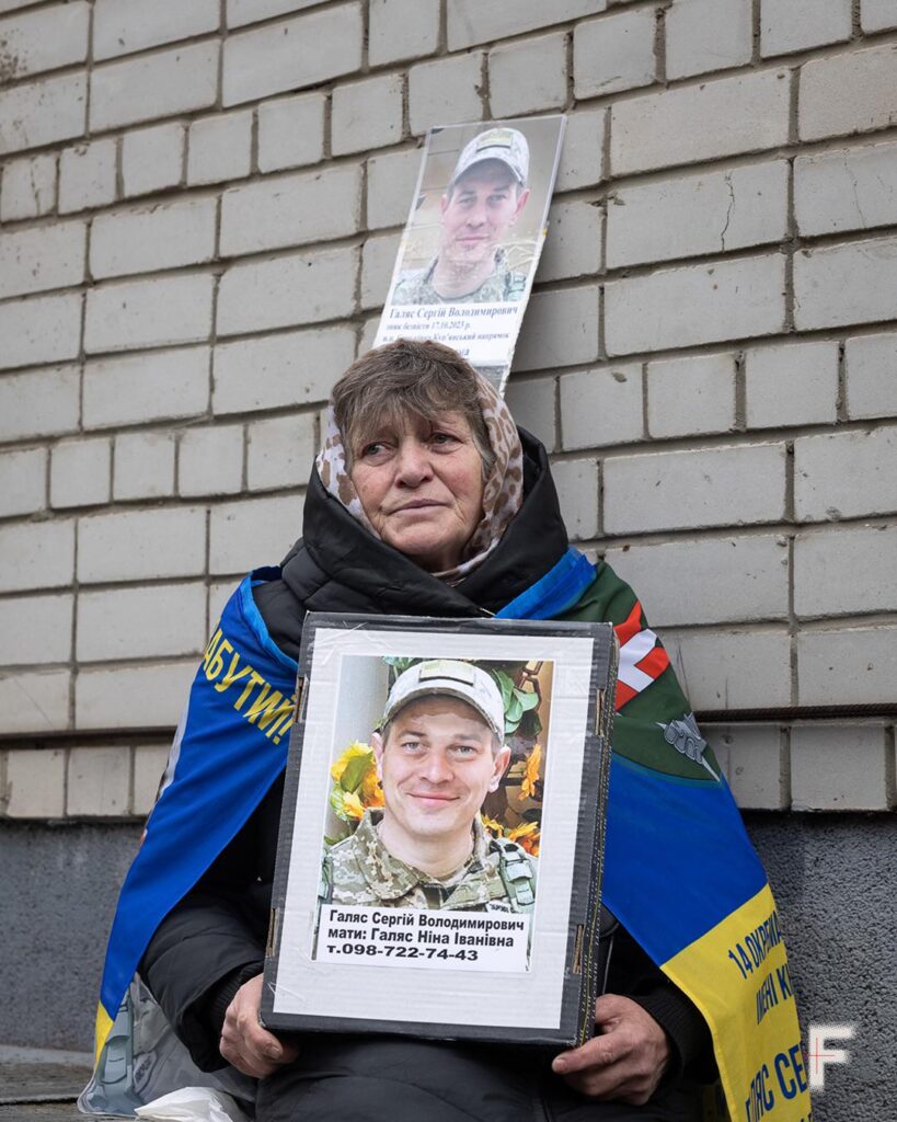 最近の捕虜交換中に、おそらく彼女の息子であるウクライナ兵士の肖像画を持つ女性