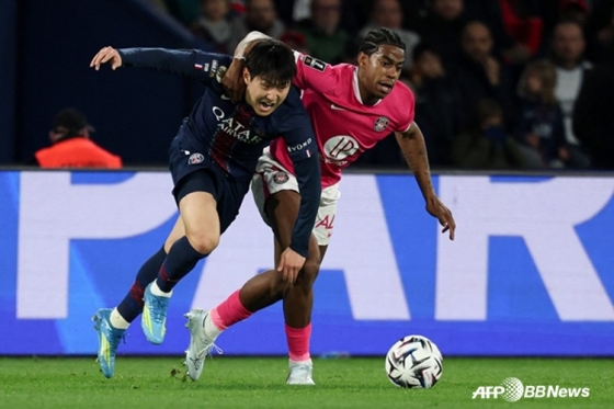 PSGFW李カンイン（左）が4日（韓国時間）、フランス·パリのパルク·デ·フランスで行われたトゥールーズとの「2025~2026フランスリーグ1」第28ラウンドでボール争いを繰り広げている。 /AFPBBNews=ニュース1