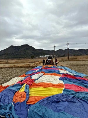 着陸した気球を回収する奈良女子大の学生たち＝奈良女子大気球部提供