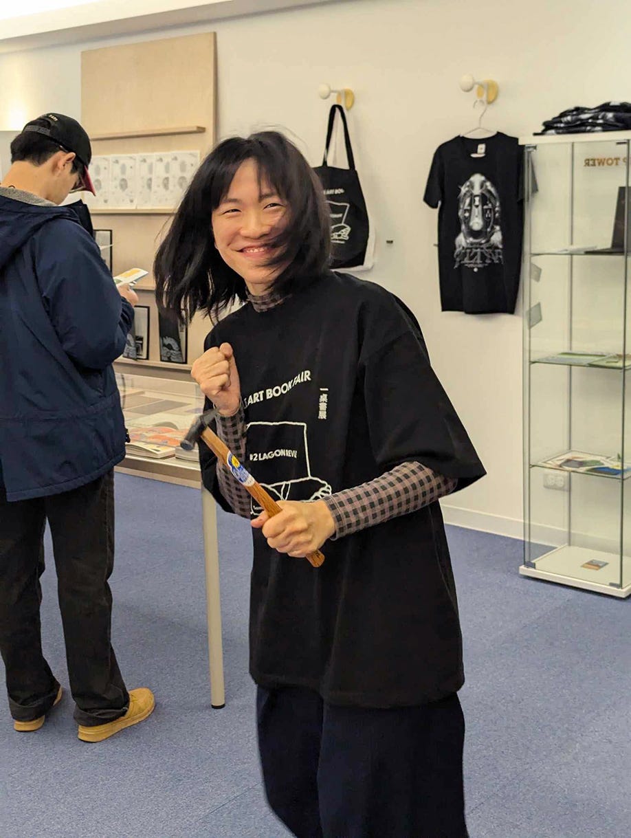 a person holding a wooden stick in a bookstore setting