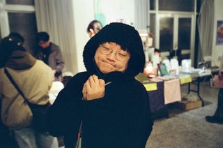 individual wearing a black hoodie in a crowded indoor setting