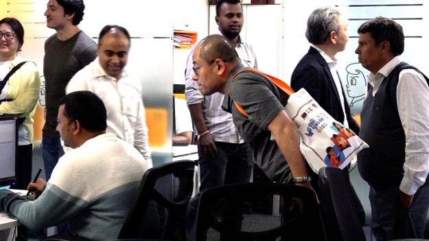 グリーン・ゴールド社でクリエイターが作業する様子を見学する佐藤Photo: Masataka Namazu