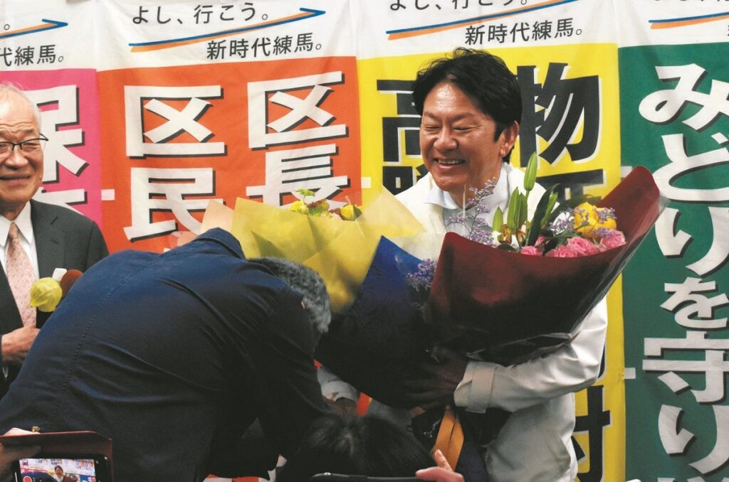 支援者から花束を受け取り笑顔を見せる吉田さん（足達優人撮影）