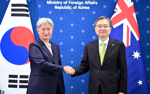 握手する趙顕外交部長官（右）とウォン外相（外交部提供）＝（聯合ニュース）≪転載・転用禁止≫