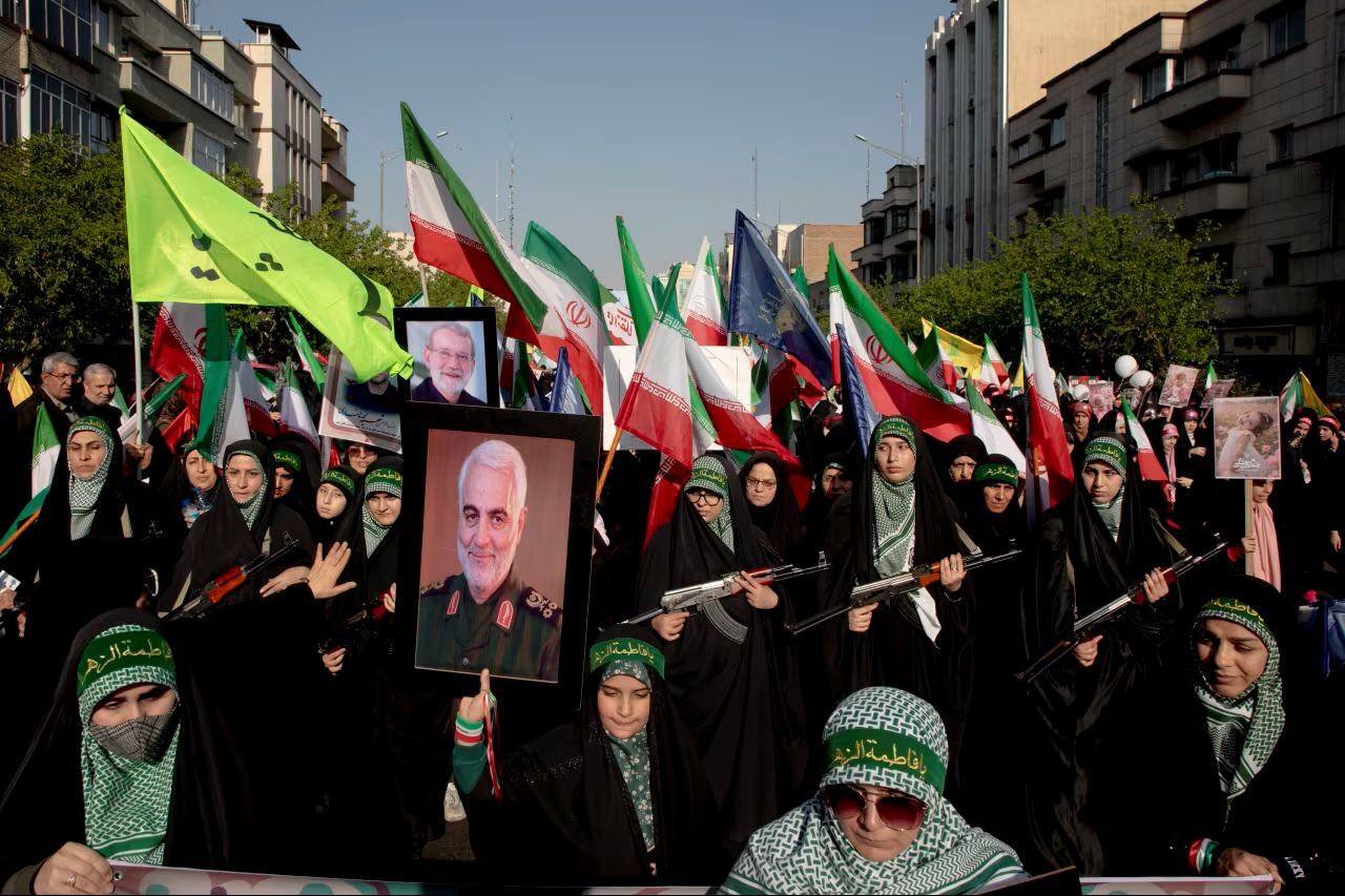 米軍のドローン攻撃で殺害されたイラン革命防衛隊のソレイマニ司令官の肖像を掲げるデモ参加者/Majid Saeedi/Getty Images