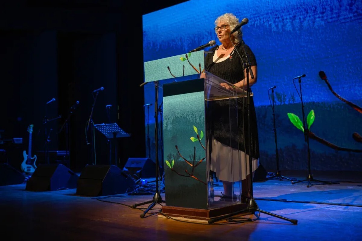 10月7日の襲撃事件の生存者で、クファルアザ・キブツ出身者のリオラ・エイロンさんが合同追悼式典でスピーチを行う様子/Alexi Rosenfeld/Getty Images