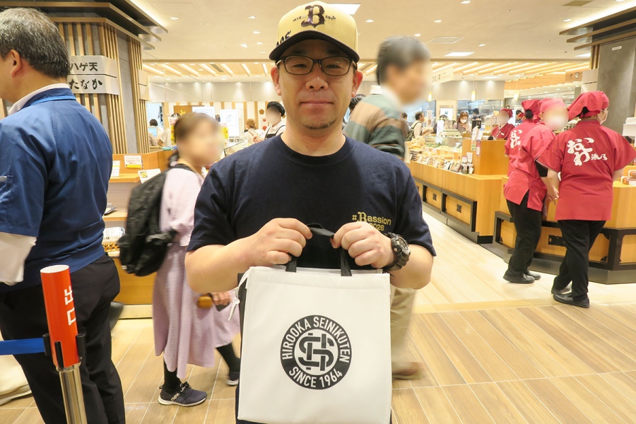 昭和町にある「広岡精肉店」にもよく訪れるという男性。オープン記念のオリジナル保冷バッグを無事ゲット（4月29日・／Lmaga.jp撮影）