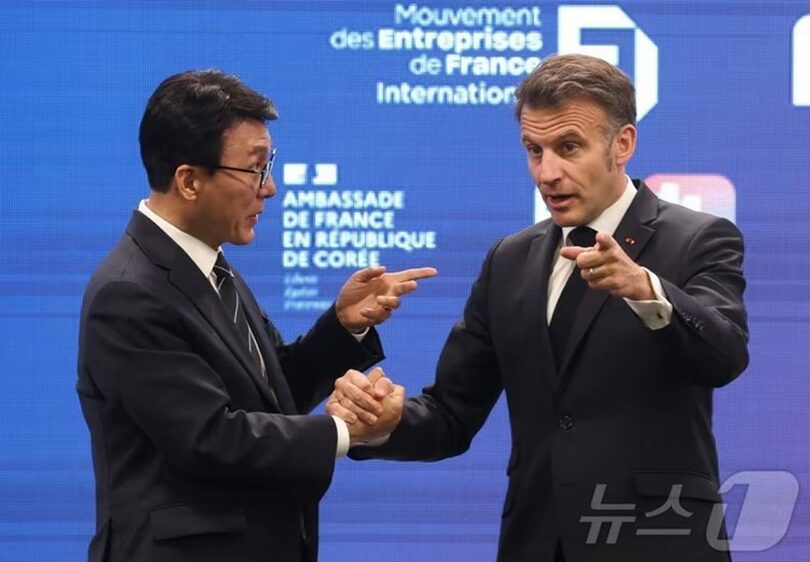 韓国のキム・ミンソク(金民錫)首相と握手を交わすマクロン大統領(c)news1