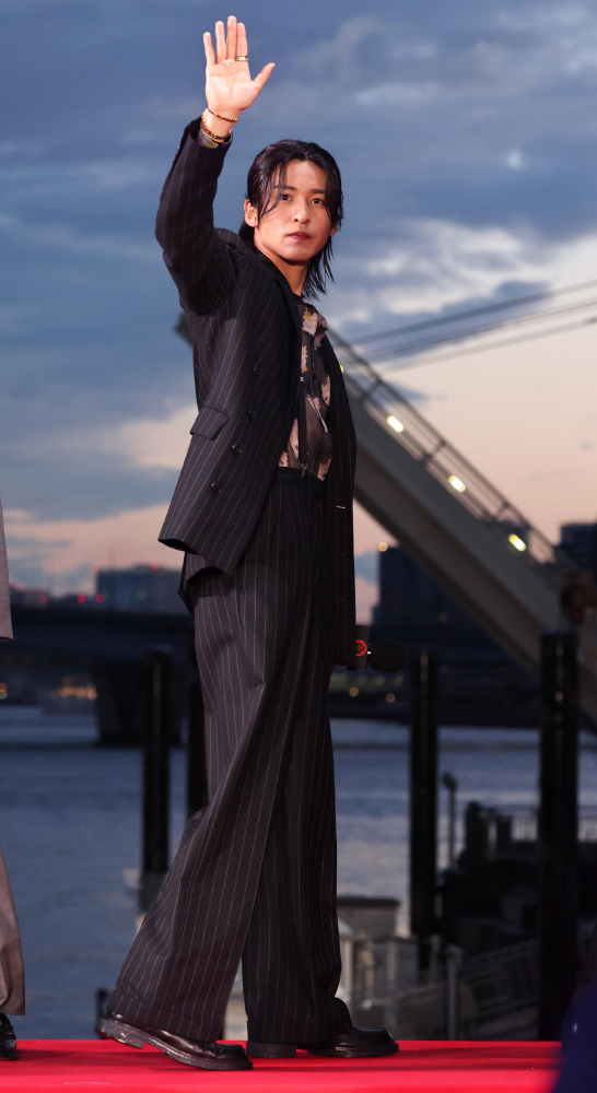 手を振っている目黒蓮さんの全身写真