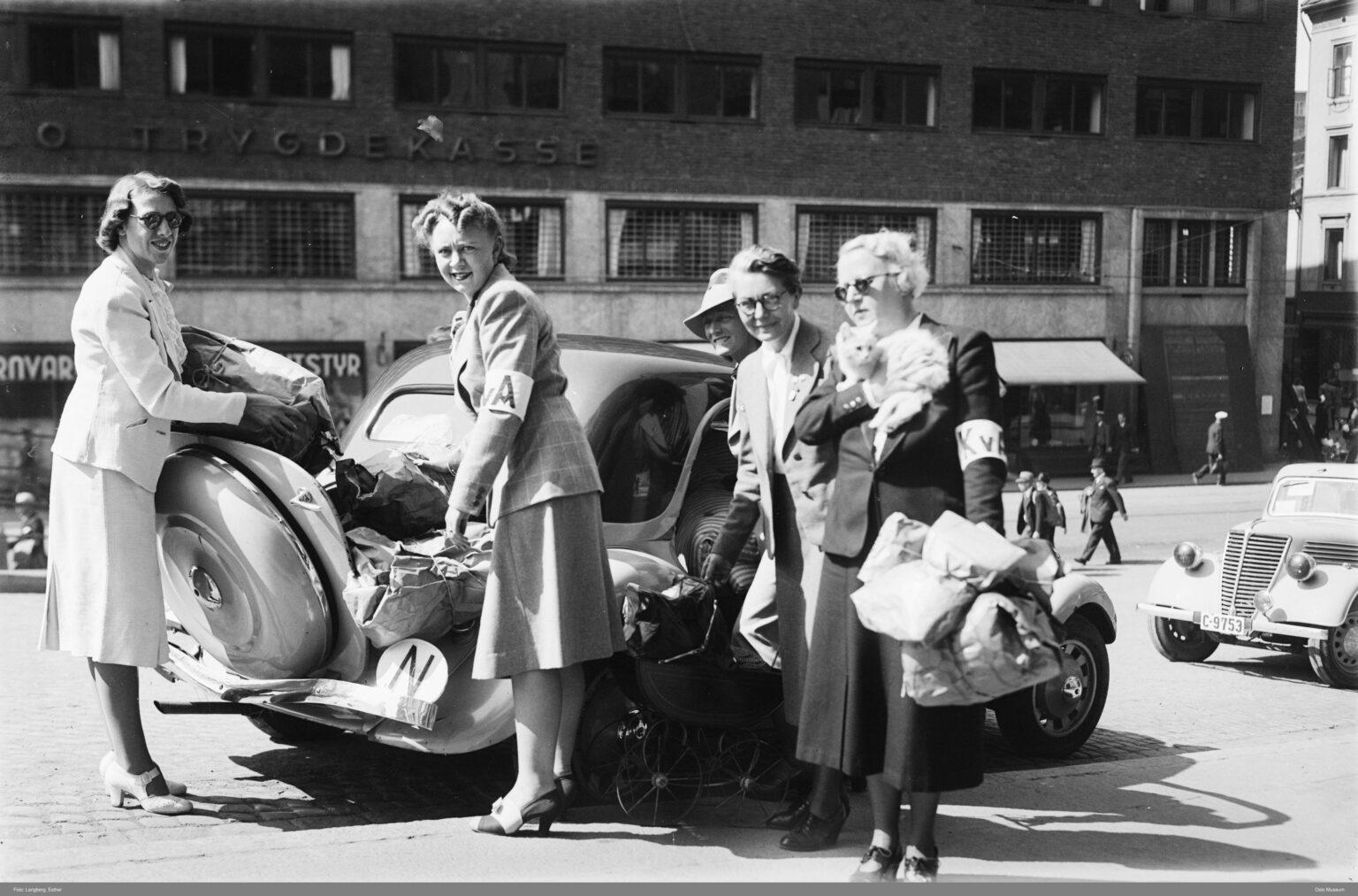 オスロ中心部で小包や物資を車に積み込むクヴィネン・アルベイドシジェルプ（女性労働救済団体）のメンバー。経済的困難と戦時中の不安の時期にノルウェーの家族や子どもたちを支援する自主救援活動の一環。 (1940)