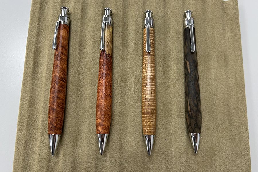 「工房 楔」の「0.5mmペンシル楔」。左から人気の「花梨こぶ杢」「花梨紅白」「ハワイアンコア」「黒柿」。イベント時の価格は1本約1万円～1万5千円以上。デルタでの取扱いもあり。在庫状況は店頭での直接確認のみ可