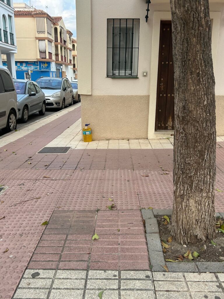 歩道にある黄色い液体のボトル: その用途についての仮説についてコメントしてください。