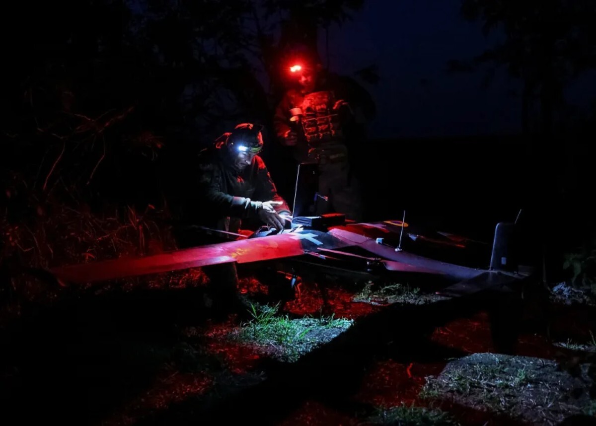 ウクライナ軍の兵士が人工知能(AI)を搭載したドローンを準備し、前線付近のロシア軍の陣地上空を飛行させる様子=18日、ウクライナ・ドネツク州/Anatolii Stepanov/Reuters