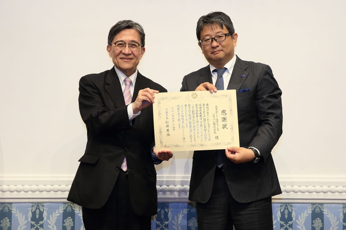 松井孝治京都市長（左）から、成田仁ステランティス・ジャパン社長（右）へと感謝状が贈呈された。