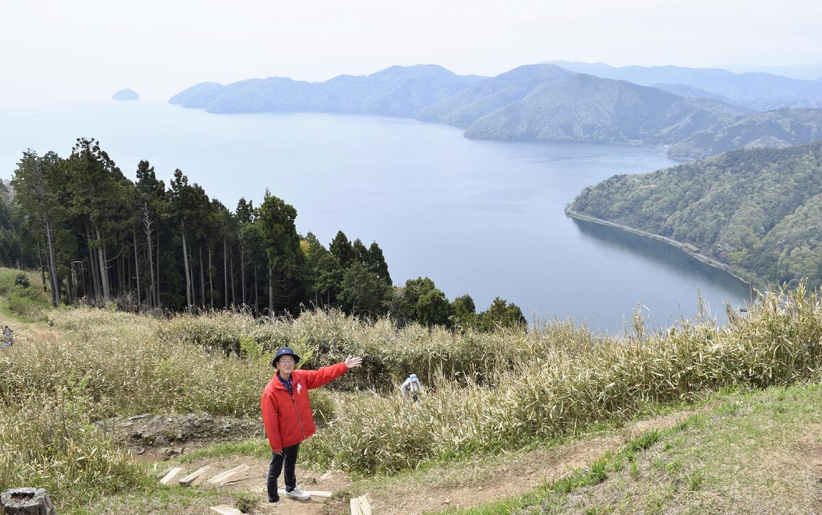視界を南に転じると、山が湖面にせり出し、その先に竹生島が浮かんだ琵琶湖が広がる（滋賀県長浜市で）