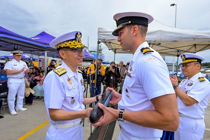 キム・ギョンリュル海軍参謀総長が25日（現地時間）、カナダ・ビクトリアのエスキモールト海軍基地で行われた国産潜水艦「島山安昌浩」（SS－III、3000トン級）と護衛艦「大田（テジョン）」（FFG、3100トン級）の入港歓迎式で、カナダ海軍ビクトリア級潜水艦「コーナーブルック」艦長クラーク・ハバード少佐に両国の海水を入れた潜水艦模型「海水カプセル」を贈呈している。［写真 海軍、ニュース1］