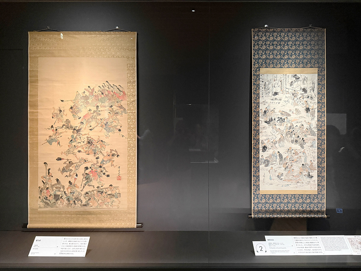 サントリー美術館「河鍋暁斎の世界」会場より (左から)河鍋暁斎《墨合戦》明治4〜22年 / 河鍋暁斎、奥原晴湖、滝和亭ほか52名《書画会図》明治9~11年頃