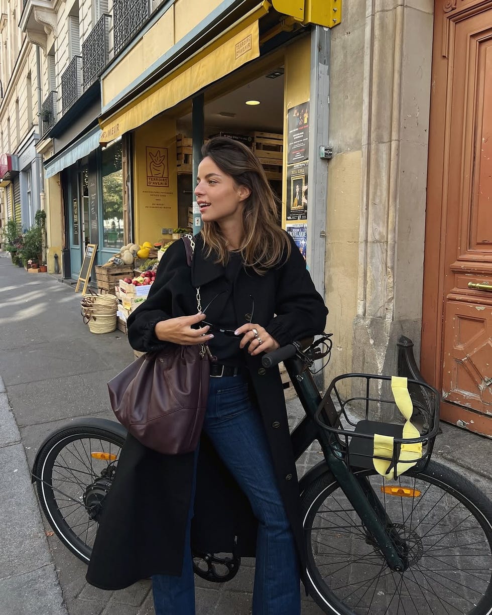 person standing next to a bicycle on a city street
