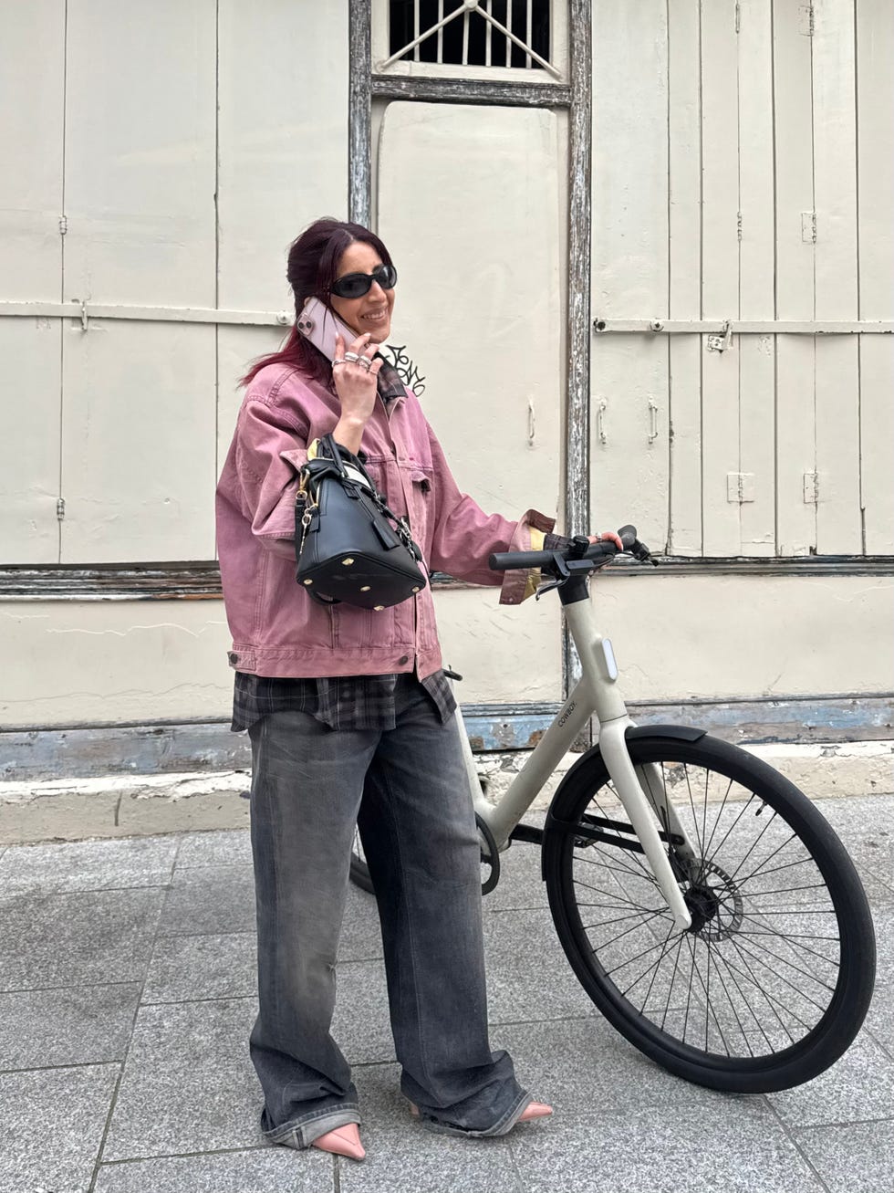 individual standing next to a bicycle engaging with a phone