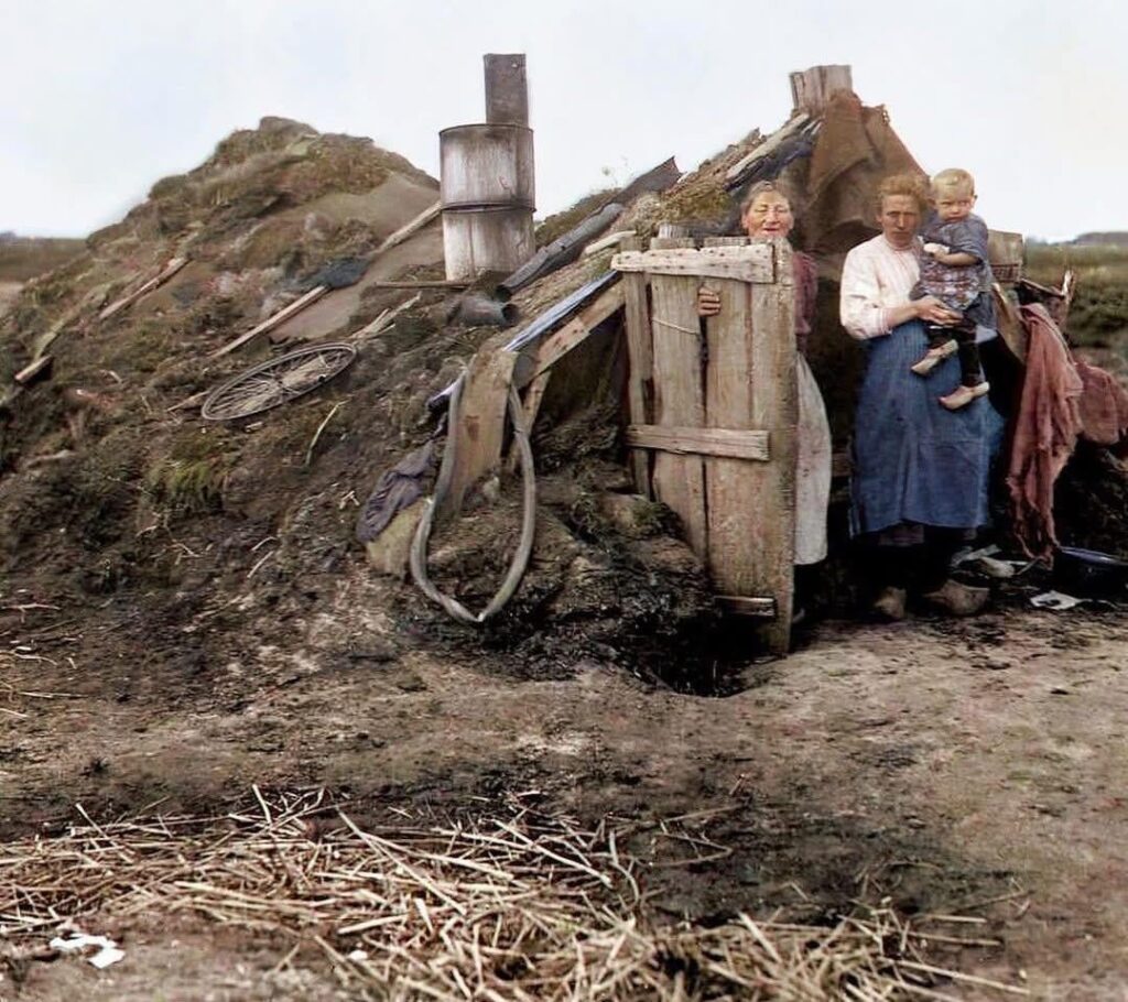 1936 年、オランダのドレンテ州にある芝生の家の居住者。屋外に立って撮影。