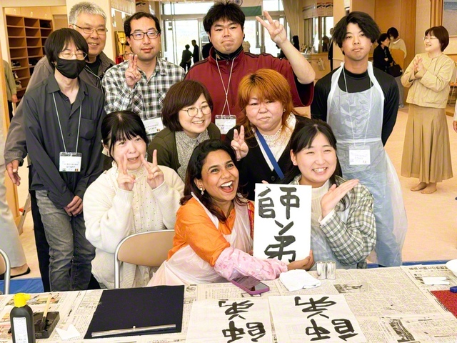 釧路総県では、おもてなし企画として書道体験を実施。日本の同志のサポートを受けつつ、「師弟」の文字を書き上げたインドの友の笑顔がはじける。交歓会では、葛西健史さん、インドのプルショッタム・ドバルさんが活動報告を行った