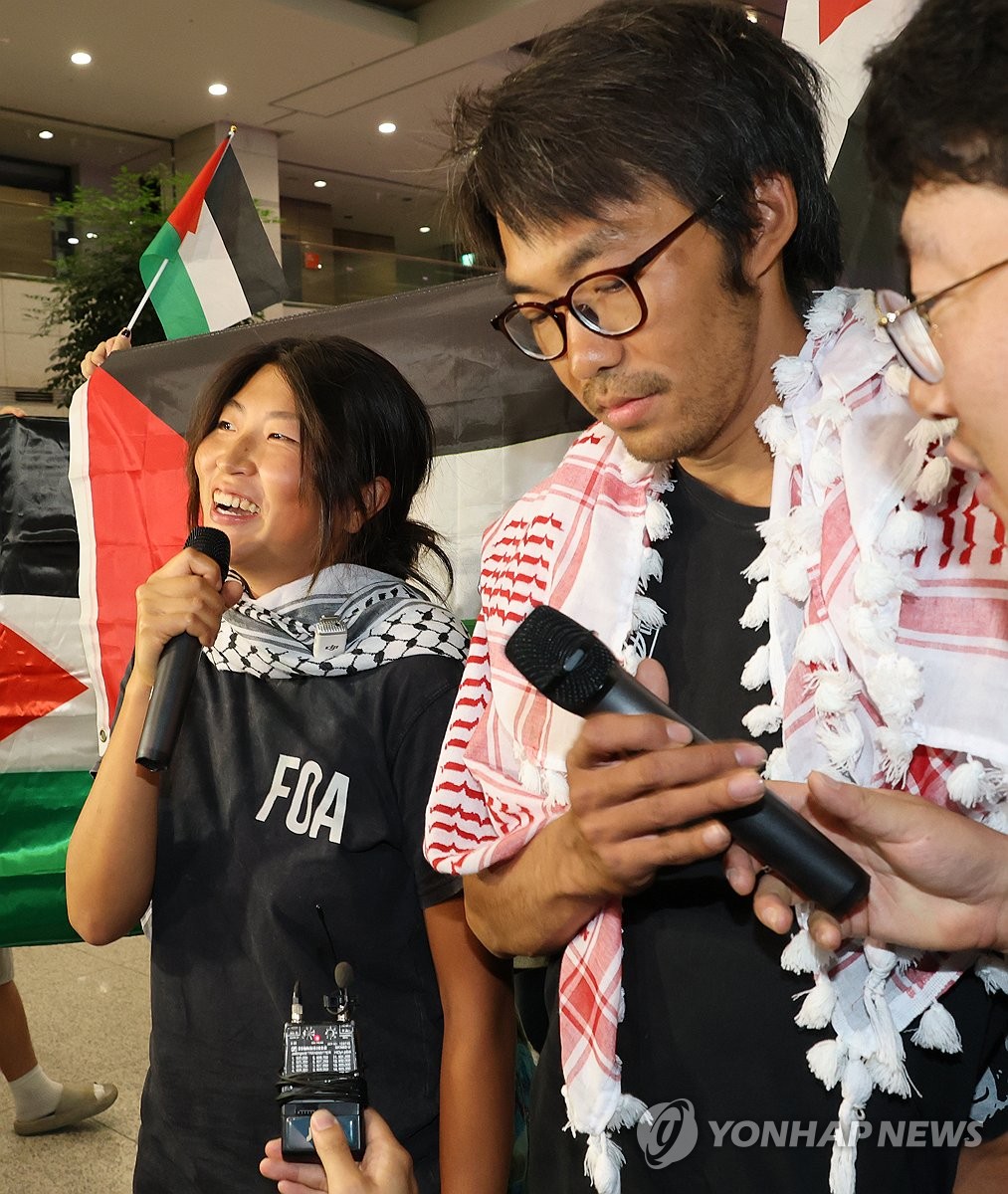 仁川空港で記者団の質問に答えるキム・アヒョンさん(左)とキム・ドンヒョンさん=22日、仁川(聯合ニュース)