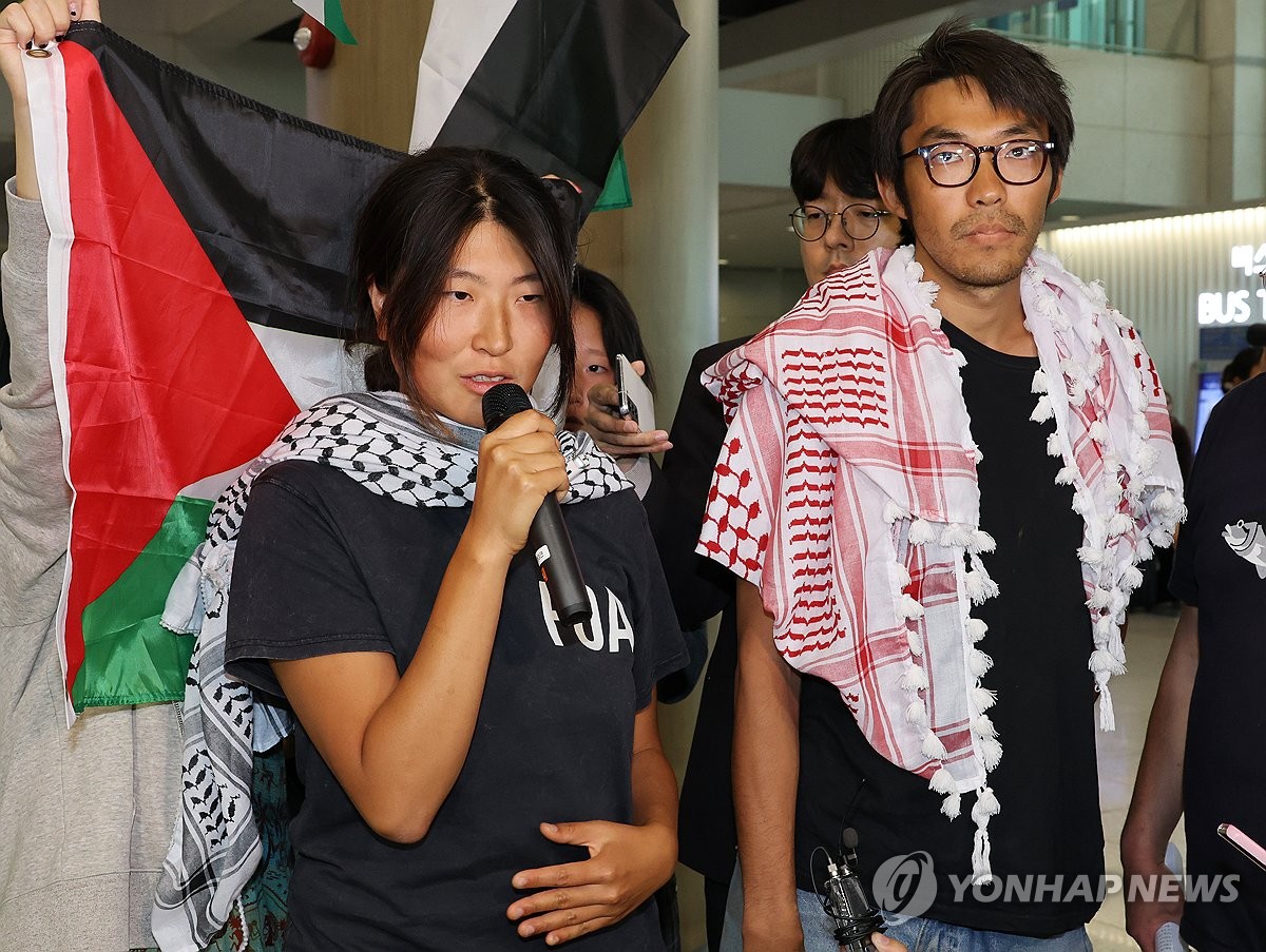 仁川空港で記者団の質問に答えるキム・アヒョンさん(左)とキム・ドンヒョンさん=22日、仁川(聯合ニュース)