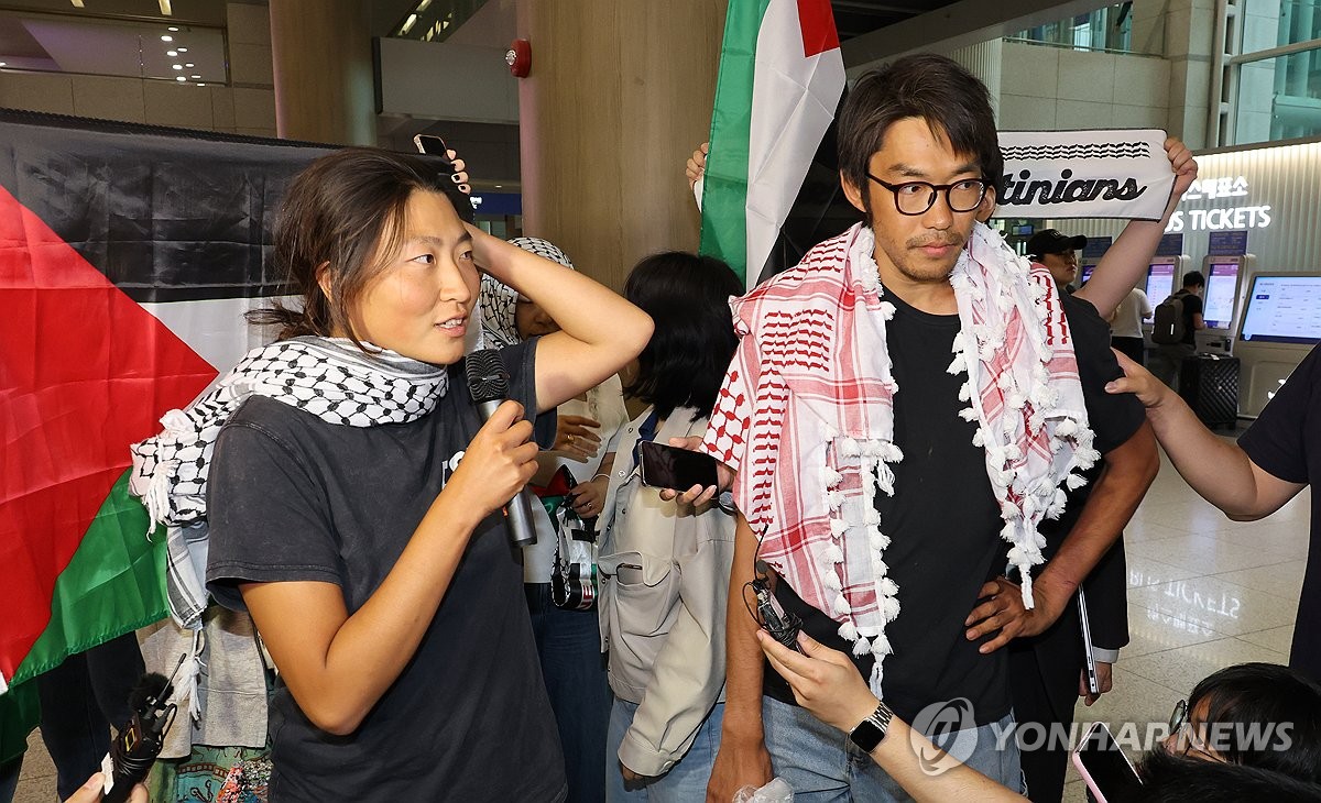 仁川国際空港に到着後、報道陣の質問に答えるキム・アヒョンさん(左)とキム・ドンヒョンさん=22日、仁川(聯合ニュース)